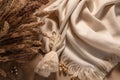 flat lay photo of beige scarf and dried flowers. background