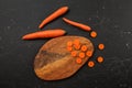 Flat lay photo, carrots some sliced to small circles on cutting board