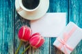 Flat lay photo with coffee cup, gift box and red tulips on wooden background. Beautiful Mother`s Day, Women`s Day or Valentine gre Royalty Free Stock Photo