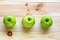 Flat lay photo of fruits. Three green, ripe and tasty apples on a natural wood background Royalty Free Stock Photo