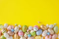 Flat lay photo of multicolored eggs and cute rabbits on yellow background