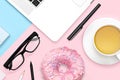 Flat lay photo of office desk with laptop notebook, glasses, sweet food donut and tea mug. Creative workspace on pastel