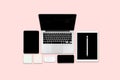 Flat lay photo of office table with laptop computer, digital tablet, mobile phone and accessories. on modern pink tone background. Royalty Free Stock Photo