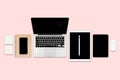 Flat lay photo of office table with laptop computer, digital tablet, mobile phone and accessories. on modern pink tone background. Royalty Free Stock Photo