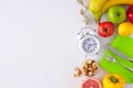 Flat lay photo of plate with cutlery, tape measure, alarm clock, nuts, vegetables and fruits Royalty Free Stock Photo