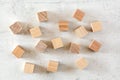 Flat lay photo - scattered plain wood cubes on white concrete like board