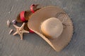 Flat lay photo of straw hat, red sandals and starfish with seashells sea sandy beach. Summer vacation concept Royalty Free Stock Photo