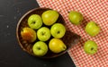 Flat lay photo - vintage wood carved bowl with apples and pears, red chequered tablecloth on black board Royalty Free Stock Photo