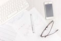 Flat lay photo of white office desk with laptop, smartphone, eyeglasses, notebook and pen with copy space background. Mockup