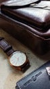 Flat lay photos of men`s products in the form of watches, leather wallets and bags as well as a cup of coffee