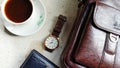 Flat lay photos of men`s products in the form of watches, leather wallets and bags as well as a cup of coffee