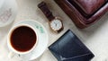 Flat lay photos of men`s products in the form of watches, leather wallets and bags as well as a cup of coffee