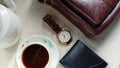 Flat lay photos of men`s products in the form of watches, leather wallets and bags as well as a cup of coffee