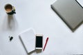 Flat-lay picture of office accessories, isolated on white background. Grey metallic laptop, white smart phone, red pen, cell Royalty Free Stock Photo