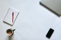 Flat-lay picture of office accessories, isolated on white background. Grey metallic laptop, white smart phone, red pen, cell Royalty Free Stock Photo