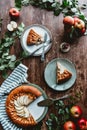 flat lay with pieces of apple pie on plates, cutlery, linen, green leaves and fresh apples arranged Royalty Free Stock Photo