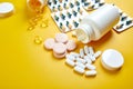 Flat lay of pills, fish oil, vitamins on yellow background