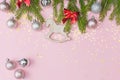 Flat lay,real fir branches decorated with Christmas balls,a red bow and a wooden toy in the form of a horse.Photo on a pink pastel Royalty Free Stock Photo