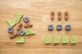 Flat lay of rearrange vary shape and color geometry block from left to right on wooden table background.