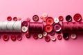 Flat lay with red buttons, thread spools on pink background Royalty Free Stock Photo