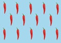 Flat lay red chili peppers pattern on ligh blue t background. Top view.