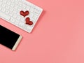 Flat lay of red glitter heart on computer keyboard and , mobile phone on pink background. online dating and long distance Royalty Free Stock Photo
