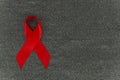 Flat lay Red ribbon HIV, AIDS day 01 December concept on gray farbric textile background mockup with space for text Royalty Free Stock Photo