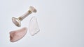 Flat lay of rose quartz massage roller and gua sha scrapers isolated over light background. Facial skin care at home Royalty Free Stock Photo