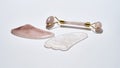 Flat lay of rose quartz massage roller and gua sha scrapers isolated over light background. Facial skin care at home Royalty Free Stock Photo