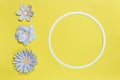 Flat lay of round card frame with color paper flower design on pastel yellow background. Copy space, floral art Royalty Free Stock Photo