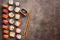 Flat lay rows of sushi rolls, soy sauce and chopsticks on a dark rustic background. View from above. Traditional asian food Royalty Free Stock Photo