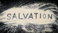 Flat lay of SALVATION word written on white sand Royalty Free Stock Photo