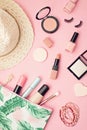 Flat lay with set of professional decorative cosmetics, makeup tools and woman spring, summer accessories over pink background