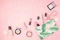 Flat lay with set of professional decorative cosmetics, makeup tools and woman spring, summer accessories over pink background