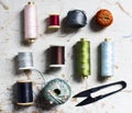 Flat lay of sewing spools tools on wooden table