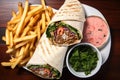 flat lay of a shawarma wrap with fries