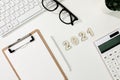 Flat lay shot of a computer keyboard, a calculator, a copybook and glasses - 2021 financial goals Royalty Free Stock Photo