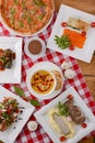 Flat lay shot of delicious italian cuisine. Delicious pizza, salmon rolls, pumpkin soup and salad on a wooden table