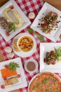 Flat lay shot of delicious italian cuisine. Delicious pizza, salmon rolls, pumpkin soup and salad on a wooden table