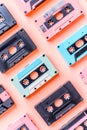 Flat lay shot of 80\'s music cassettes lined up on a pastel pink background. Nostalgia concept