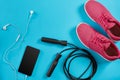 Flat lay shot of Sport equipment. Sneakers, jump rope, earphones and phone on blue background. Royalty Free Stock Photo