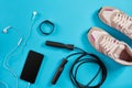 Flat lay shot of Sport equipment. Sneakers, jump rope, earphones and phone on blue background. Royalty Free Stock Photo