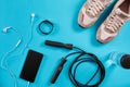 Flat lay shot of Sport equipment. Sneakers, jump rope, earphones and phone on blue background. Royalty Free Stock Photo