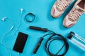 Flat lay shot of Sport equipment. Sneakers, jump rope, earphones and phone on blue background. Royalty Free Stock Photo