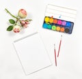 Flat lay sketchbook watercolor brushes paper rose flowers