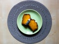 Flat lay of slices of pumpkin pie on green plate. Seasonal food background