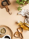 Flat lay of small bowls various dry spices, wood kitchen utensils, fresh mint in pot olive oil in glass bottle on beige background