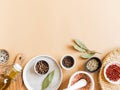 Flat lay of small bowls various dry spices, wood kitchen utensils, olive oil in glass bottle on beige background. Top view. copy