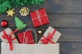 Flat lay of small gift boxes tired with ribbon, new year stuff, green tinsel on wooden background, copyspace for text. Royalty Free Stock Photo