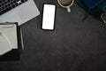 Flat lay smart phone with blank screen, laptop, notepad and coffee cup on black stone background Royalty Free Stock Photo